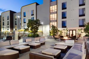 SpringHill Suites by Marriott Los Angeles Burbank/Downtown في بربانك: ساحة مع مقاعد وكراسي أمام المبنى