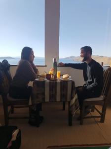 a man and a woman sitting at a table at Sol y Luna ISLA DEL SOL in Comunidad Yumani