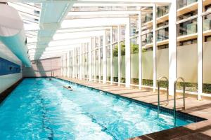 uma pessoa a nadar numa piscina num edifício em Ocean view apartment close to CBD with indoor pool. em Melbourne