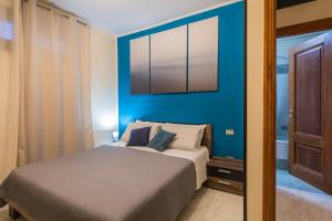 una camera con un letto con una parete blu di Il Borgo degli Artisti a Montoro Inferiore