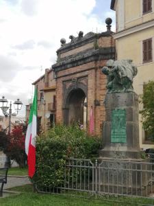 een standbeeld voor een gebouw met een vlag bij Bee Happy BnB in Campagnano di Roma