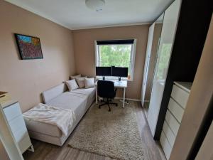 1 dormitorio con sofá y escritorio con ordenador en Large apartment - Perfect for Aqua Nor, en Trondheim
