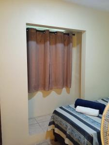Rioli quarto 2 في كاروارو: غرفة نوم بها سرير ونافذة بها ستارة
