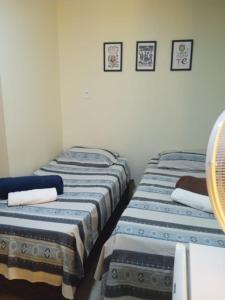- deux lits assis l'un à côté de l'autre dans une pièce dans l'établissement Rioli quarto 2, à Caruaru