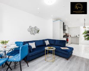 a living room with a blue couch and a table at 2 Bedroom Apartment by AV Stays Short Lets Southwark London in London