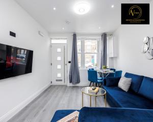 een woonkamer met een blauwe bank en een tafel bij 2 Bedroom Apartment by AV Stays Short Lets Southwark London in Londen