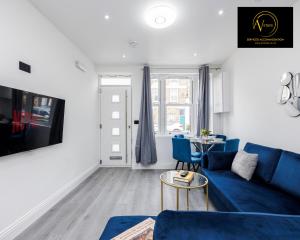 a living room with a blue couch and a table at 2 Bedroom Apartment by AV Stays Short Lets Southwark London in London