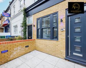 a building with a blue door and a brick wall at 2 Bedroom Apartment by AV Stays Short Lets Southwark London in London