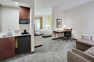 a hotel room with a kitchen and a bedroom at SpringHill Suites Milford in Milford