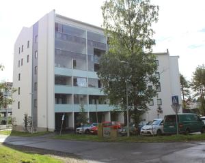 een wit gebouw met auto's ervoor geparkeerd bij Tuomas´ luxurious suites, Mustikka in Rovaniemi