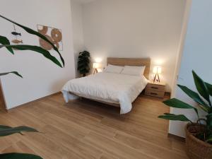 een witte slaapkamer met een bed en een potplant bij Mi Casita De Garraf in Garraf