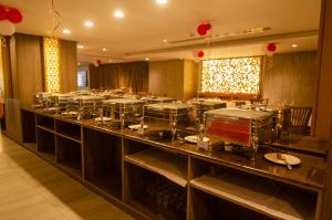 un ristorante con un lungo bancone con piatti sopra di Pearl Harbour Business Hotel a Chittagong