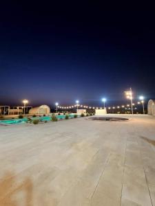 a large parking lot at night with street lights at Desert Breeze Farm Resort in Al Ḩamrānīyah