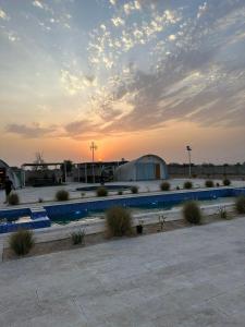 a parking lot with a fence and a building at Desert Breeze Farm Resort in Al Ḩamrānīyah