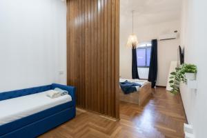 ein Wohnzimmer mit einem blauen Sofa und ein Schlafzimmer in der Unterkunft MareLuna Apartment in Neapel