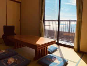 Zimmer mit einem Tisch und einem großen Fenster in der Unterkunft 民宿たかはま Takahama Guest house 