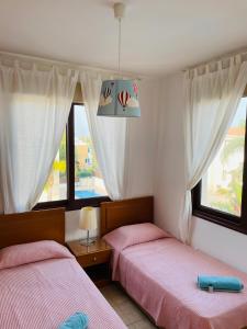 - 2 lits dans une chambre avec 2 fenêtres dans l'établissement Amazing Villa with a private pool, à Protaras