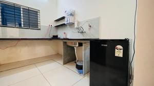 a kitchen with a counter and a refrigerator in a room at Home Escape Luxé Private Villa- Indralaya in Ujjain
