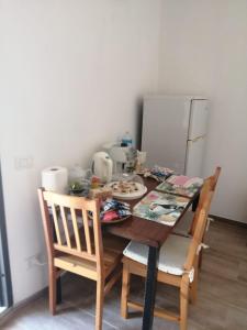 een eettafel met 2 stoelen en een koelkast bij Elia's House in Padru