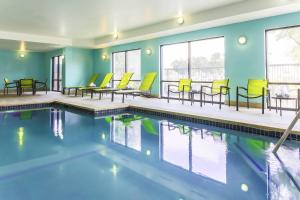 una piscina con sedie gialle e tavoli in un edificio di SpringHill Suites by Marriott Austin Parmer/Tech Ridge ad Austin