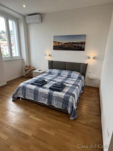 1 dormitorio con 1 cama con manta a cuadros en Casa del Caffè en Trieste