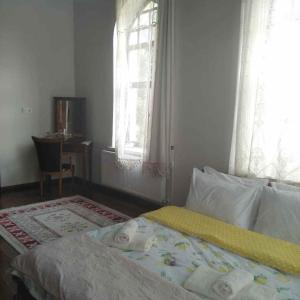 um quarto com uma cama, uma secretária e janelas em Frig Evi em Sabuncu
