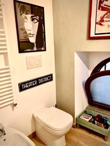 ein Bad mit WC und ein Schild an der Wand in der Unterkunft The Place in Orvieto