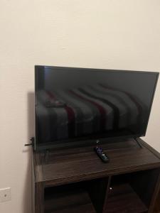 a flat screen tv on a wooden stand with a remote control at Lake house # 1 in Tacoma