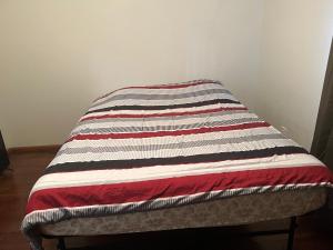 a bed with a striped blanket on top of it at Lake house # 1 in Tacoma