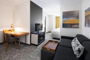 a living room with a couch and a table and a bed at SpringHill Suites Austin Round Rock in Round Rock
