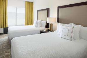 2 Betten in einem Hotelzimmer mit weißen Kissen in der Unterkunft SpringHill Suites Austin Round Rock in Round Rock