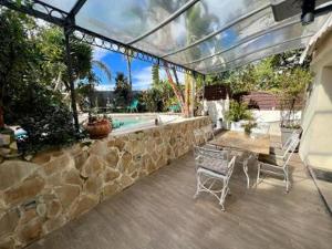 a patio with a table and chairs and a stone wall at VILLA BEAUSEJOUR in Cannes