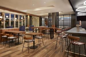 a restaurant with wooden tables and stools at Courtyard by Marriott Calgary Airport in Calgary