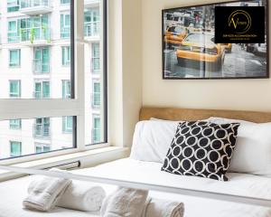 Bett in einem Zimmer mit einem großen Fenster in der Unterkunft 2 Bedroom Apartment by AV Stays Short Lets & Serviced Accommodation in London