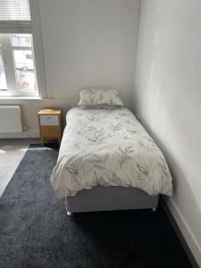 a bedroom with a bed in a white room at 2BD Victorian Terrace House Ramsgate in Ramsgate
