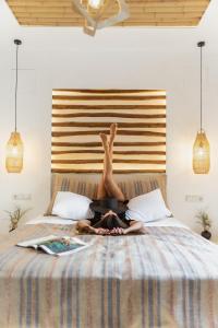 a person laying on a bed with their legs in the air at Naxian Serenity Suites in Agia Anna Naxos