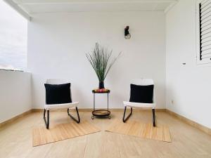 Dos sillas en una habitación con un jarrón sobre una mesa. en Casa del Mayor, en Playa Honda