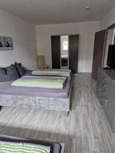 a bedroom with two beds and a television in it at Gelis Ferienwohnung in Aichstetten