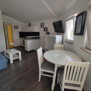 eine Küche und ein Esszimmer mit einem Tisch und Stühlen in der Unterkunft Pansion Veso Medjugorje in Međugorje