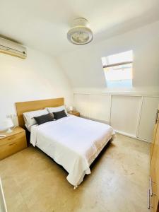 een slaapkamer met een groot wit bed en een raam bij Fuengirola Sweet Apartament in Fuengirola