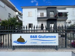 un panneau sur une clôture devant un bâtiment dans l'établissement B&B Giulianova, à Giulianova