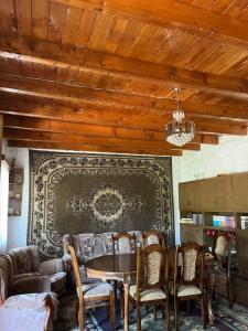 a living room with a table and chairs and a couch at Guesthouse "Kvara"- Mukhuri in Chʼkhorotsqu