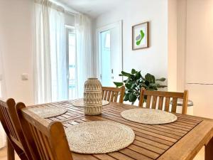 einem Esstisch mit Stühlen und einem Holztisch in der Unterkunft Duplex apartment 2 min from the beach in Nazaré