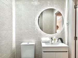 ein weißes Badezimmer mit einem Waschbecken und einem Spiegel in der Unterkunft Duplex apartment 2 min from the beach in Nazaré