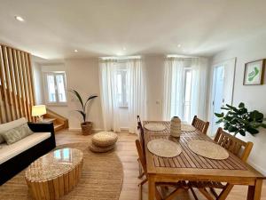 ein Wohnzimmer mit einem Tisch, Stühlen und einem Sofa in der Unterkunft Duplex apartment 2 min from the beach in Nazaré