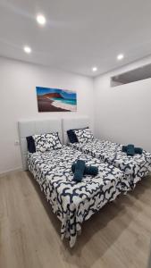 1 dormitorio con 1 cama con edredón blanco y negro en Mariposa Azul en Adeje