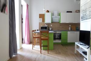 una cocina con armarios verdes y blancos y una mesa en Urocze i ciche mieszkanie w spokojnej okolicy en Cracovia