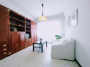 a living room with a white couch and a table at Alojamiento Caldas Centro in Caldas de Reis
