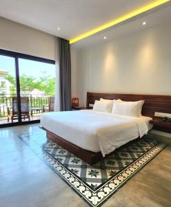 a bedroom with a large bed and a large window at DACO Hotel in Siem Reap