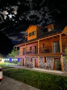 a large wooden house at night at Gegest Hotel in Theth